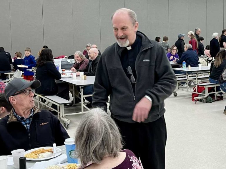 Father David Meng greets parishioners attending the second fish fry dinner.